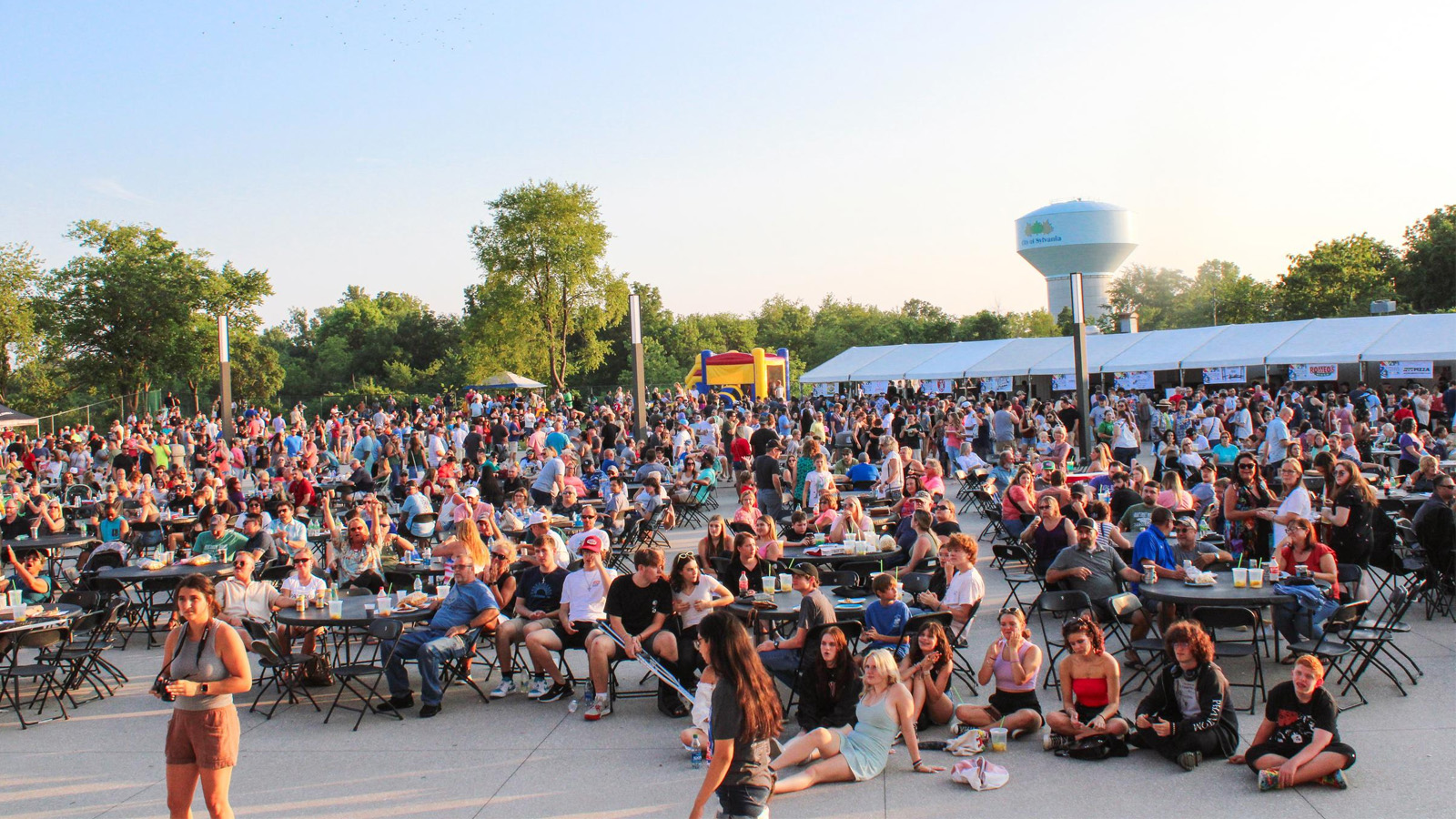 Crowd of people eating pizza at tables